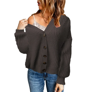 Detail of loose V-neck knitted cardigan with dark buttons and thick knit texture