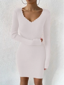 Détail du col en V festonné et de la maille côtelée sur cette mini robe rose moulante