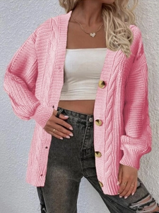 Detail of pink cable knit cardigan featuring three large buttons and textured sleeves