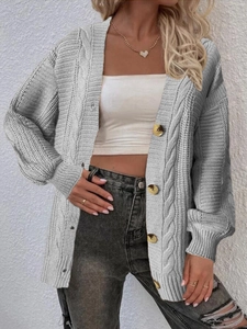 Close-up of cable-knit pattern and wood-textured buttons on light grey cardigan