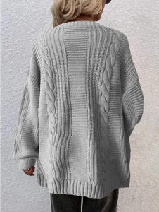 Detail of grey oversized cable knit cardigan featuring textured back braiding for autumn