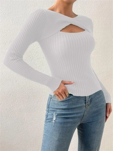 Vue détaillée du nœud croisé et de la découpe sur un pull en maille côtelée blanche