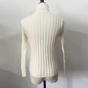 Detailed back view of a cream-colored ribbed knit turtleneck sweater on a mannequin