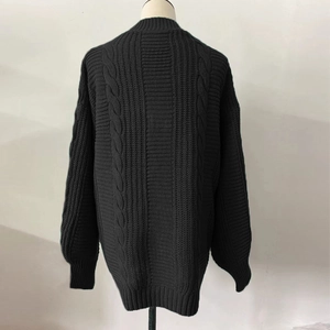 Detailed back view of a black cable knit cardigan with classic braided patterns and texture