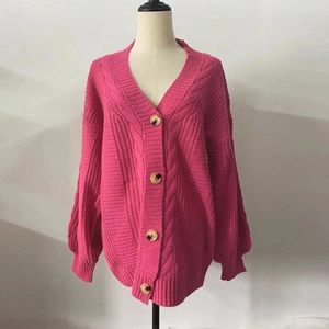 Close-up detail of hot pink cable knit cardigan featuring textured wooden buttons