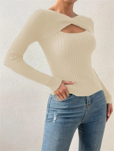 Vue détaillée du design torsadé et ajouré sur un pull en maille côtelée beige à manches