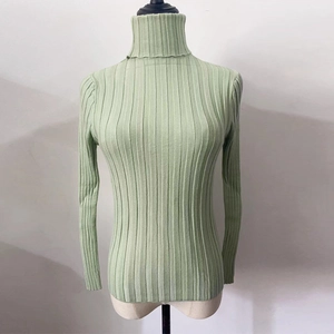 Detail of high neck ribbed knit sweater in light green with vertical texture