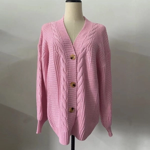 Detail of pink cable knit cardigan with V-neckline and marbled brown buttons