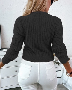 Vista posteriore di un maglione nero a coste a maniche lunghe da donna e trama del tessuto