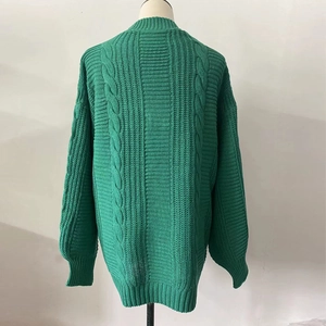 Detail view of green cable knit cardigan back with chunky cable patterns and ribbing