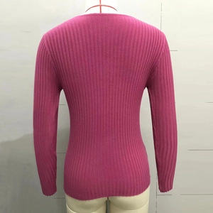 Gros plan sur la texture en maille côtelée rose de ce pull ajusté à manches longues