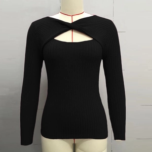 Détail d'un pull en maille côtelée noire avec nœud irrégulier et découpe au décolleté