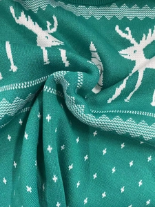 Detail of green Christmas sweater showing reindeer pattern and soft knit texture