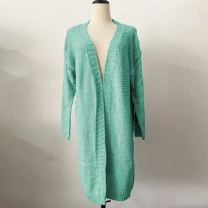 Close-up detail of mint green chunky knit cardigan featuring textured knit patterns and long sleeves