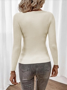Detail view of the ribbed texture and fitted back design of this beige knit sweater top