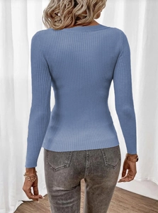 Close-up back view of a blue ribbed long sleeve sweater paired with grey jeans