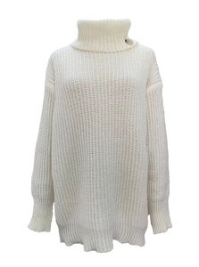 Close-up of ribbed white knit sweater featuring a turtle neck and side button detail