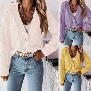 Detail view of chunky knit v-neck cardigan sweater with pearl buttons in three colors