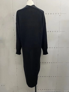 Detail view of the black long-line knit cardigan back with ribbed cuffs and drop shoulder