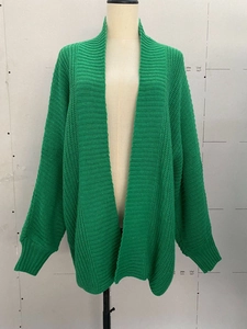 Detail of bright green oversized knit cardigan showing ribbed cuffs and chunky texture