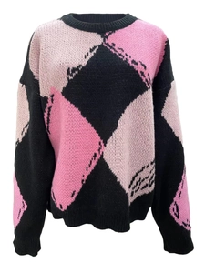 Détail d'un pull en maille à losanges tricolores avec col rond et coupe surdimensionnée