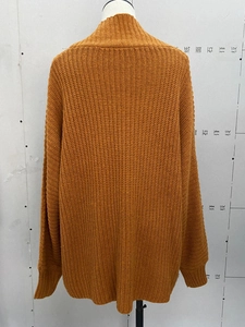 Detail view of mustard yellow chunky knit sweater back with ribbed cuffs and drop shoulder