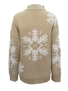 Detail view of khaki knit sweater showing white snowflake pattern and ribbed cuffs