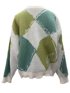 Détail d'un pull en tricot à motif argyle surdimensionné en vert et blanc élégant