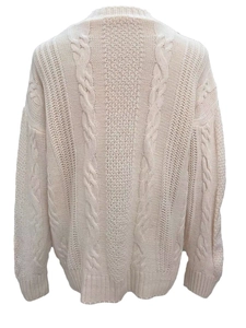 Close-up of cream chunky knit cardigan showing cable knit texture and ribbed hem detail