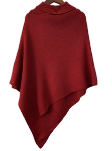 Detail of dark red knit turtleneck poncho sweater featuring a ribbed collar and asymmetric hem
