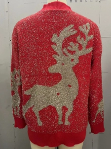 Detail of red Christmas knit sweater featuring a golden sequin reindeer on the back