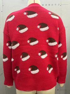 Detail of red Christmas sweater with 3D embroidery Santa hats and soft pom-poms