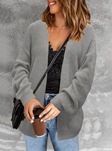 Detail of grey chunky knit cardigan showing thick texture and ribbed cuffs on the sleeve