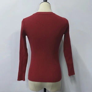 Close-up of red ribbed knit sweater back detail showing vertical texture and stitching