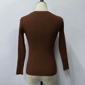 Detail of dark brown knit sweater with ribbed texture and round neck on mannequin back