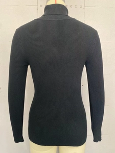 Detail view of the black ribbed knit texture and slim fit high neck sweater on a mannequin