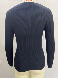 Detailed back view of a slim-fit black ribbed knit sweater with long sleeves on a mannequin