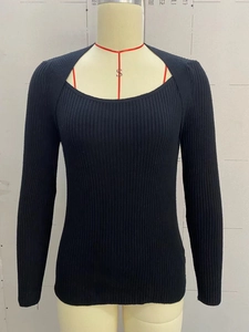 Detail of black ribbed knit sweater featuring a unique square neckline and layered design