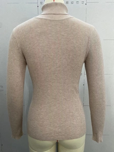 Back view of apricot ribbed knit turtleneck sweater showing thick vertical texture