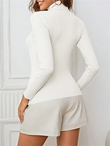 Detail view of white ribbed knit turtleneck sweater showing slim fit back design on model