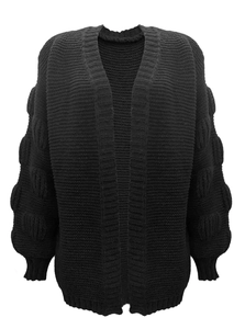 Detailed view of black knitted cardigan featuring textured pom-pom sleeves and ribbed cuffs