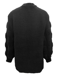 Detail of black knit cardigan featuring unique textured bubble sleeves and ribbed cuffs