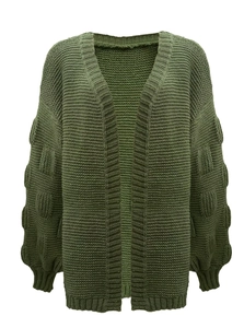 Detail of dark green chunky knit cardigan with textured bubble sleeves and puffy lantern style