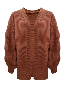 Detail of brick red knit cardigan featuring bubble sleeves and chunky knit texture