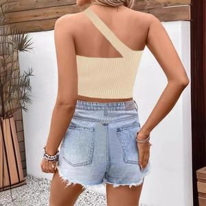 Dettaglio del crop top in maglia a coste beige con design monospalla asimmetrico da donna