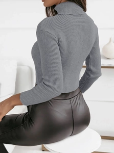 Close-up of the grey ribbed knit turtleneck sweater texture and sleek black faux leather pants