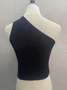 Detail of black one-shoulder ribbed knit crop top showing fabric texture and stretch