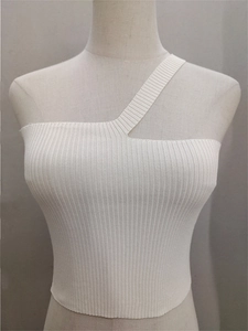 Dettaglio del tessuto in maglia a costine bianca con spallina singola asimmetrica