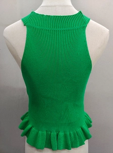 Detail showing emerald green ribbed knit texture and ruffled hem on sleeveless top