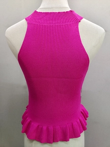 Detail shot of rose red sleeveless knitted crop top with ruffled hem and ribbed texture